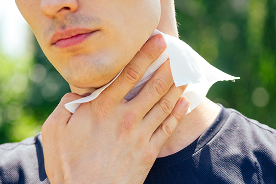 Men wiping neck with body wipes